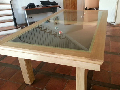 Orion 7ft pool table, in light wood finish with black cloth with glass dining pieces in place over table.